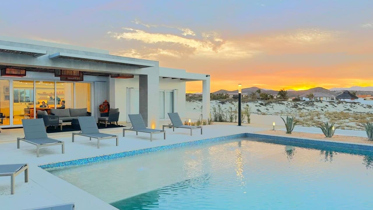 Modern desert house with pool at sunset.