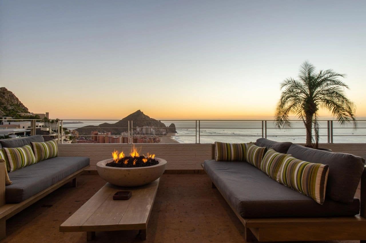 Ocean view terrace with firepit at sunset.