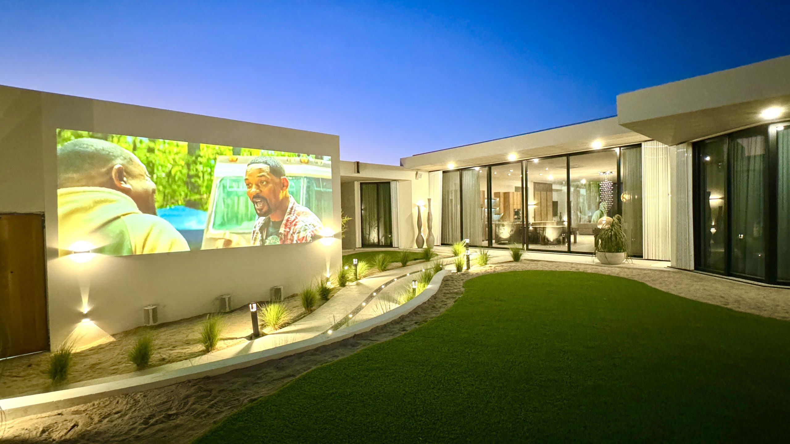 Modern home exterior with outdoor projection at night